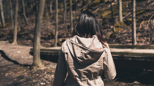 Rear view of woman standing in forest