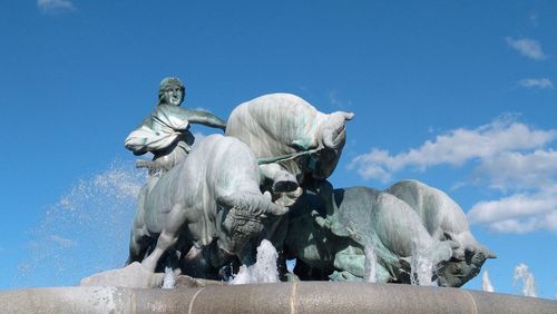 Low angle view of statue against blue sky