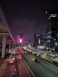 Traffic on road in city against sky at night