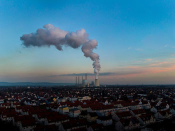 Smoke emitting from chimney against blue sky