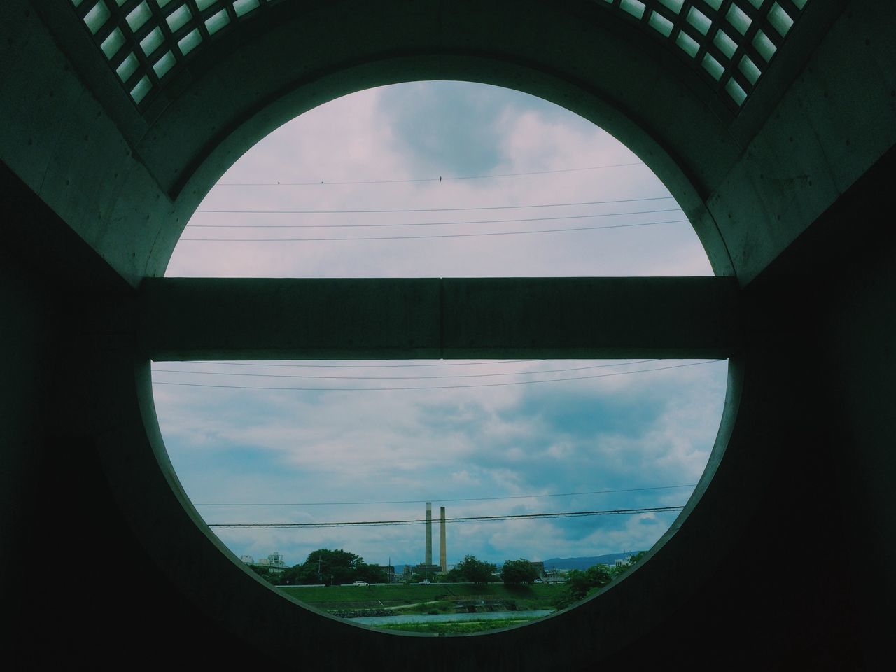 indoors, sky, built structure, architecture, window, cloud - sky, glass - material, transparent, cloud, transportation, reflection, no people, low angle view, circle, day, airplane, building exterior, geometric shape, water, cloudy