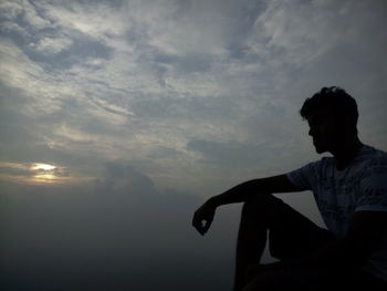 Silhouette man looking at sunset sky
