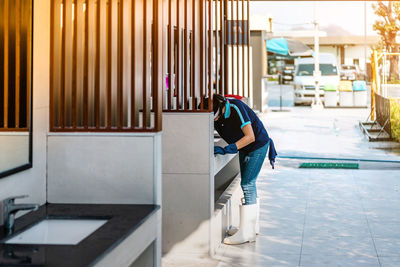 Rear view of woman sitting on corridor of building