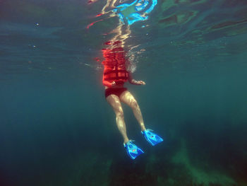 Low section of person swimming in sea