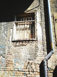 Low angle view of window on wall of old building