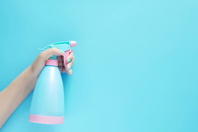 Midsection of woman holding umbrella against blue background