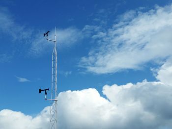 Low angle view of communications tower against blue sky