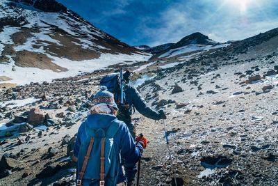 Rear view of people on snow covered mountain