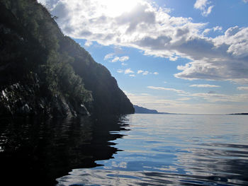 Scenic view of sea and mountains against sky