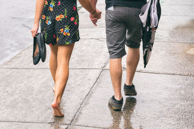 Low section of couple walking on street