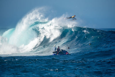 People in sea against sky