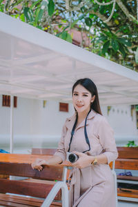 A woman carrying a camera on a trip.