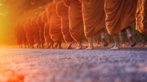 Low section of monks walking on field