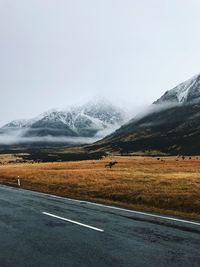 Road by mountains against sky