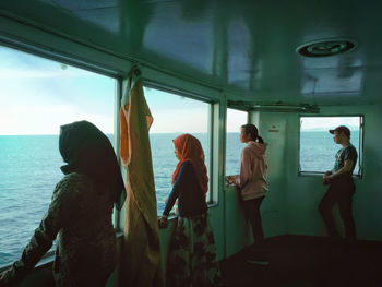People standing by sea against sky