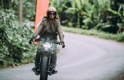 Portrait of man riding motorcycle on road