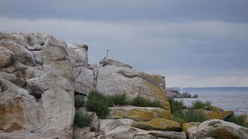 Rock formations by sea against sky