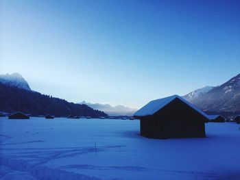 Scenic view of snow covered mountains against clear blue sky