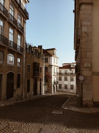 Street amidst buildings in city against clear sky