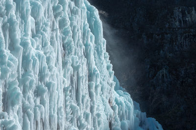 Icicles on snow against sky