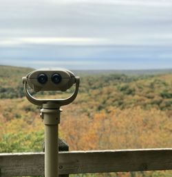 Close-up of coin-operated binoculars against sky