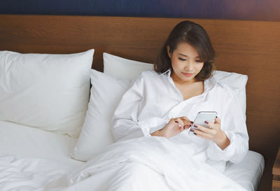 High angle view of woman sitting on bed