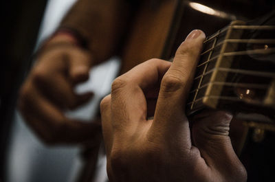 Midsection of man playing guitar