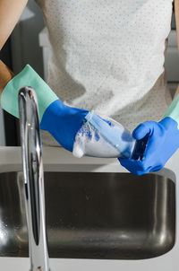 Midsection of woman washing glasses