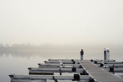 Rear view of man on water against clear sky