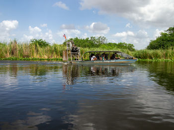 People in lake against sky