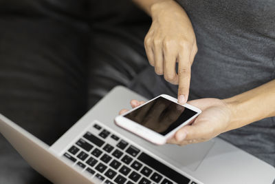 Midsection of man using mobile phone