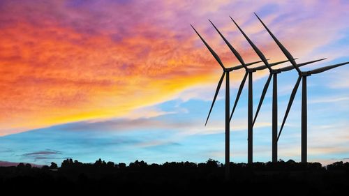 Low angle view of silhouette windmill against sky during sunset