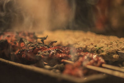 Close-up of roasting chicken in skewers at market stall