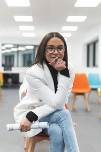 Portrait of senior woman standing against wall