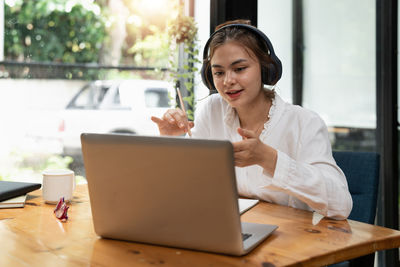 Young woman using laptop at table