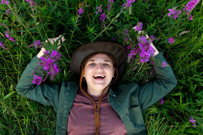 Portrait of smiling young woman standing against plants