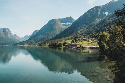 Scenic view of lake by mountains against sky