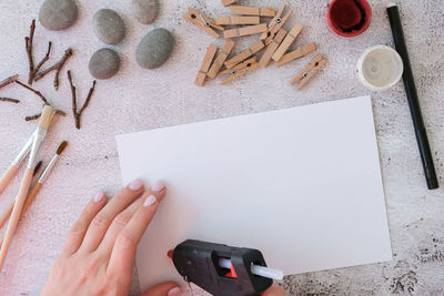 High angle view of hand using mobile phone on table