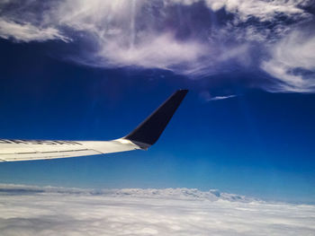 Cropped image of airplane flying over clouds