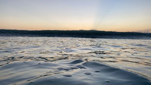 Scenic view of snow covered land against sky during sunset