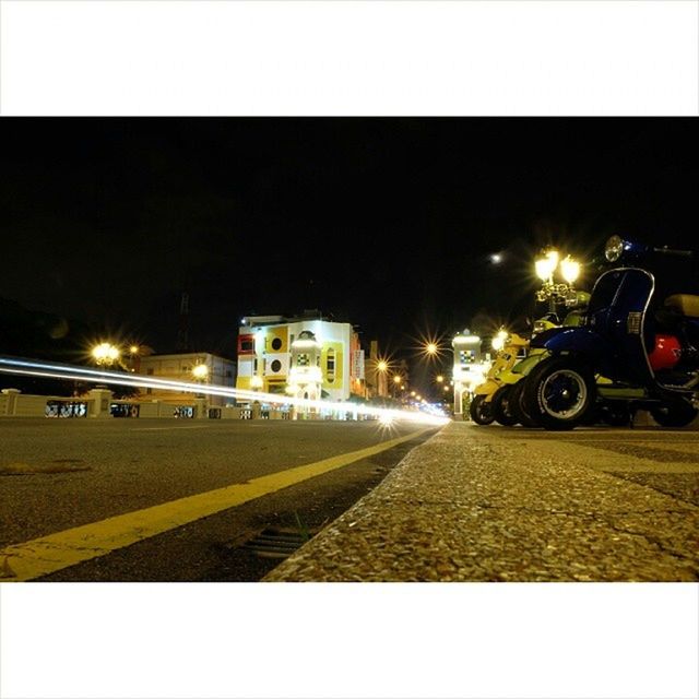 transportation, night, land vehicle, transfer print, illuminated, building exterior, mode of transport, street, architecture, car, built structure, auto post production filter, road, city, street light, bicycle, city street, one person, outdoors, copy space