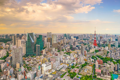 High angle view of city buildings against cloudy sky