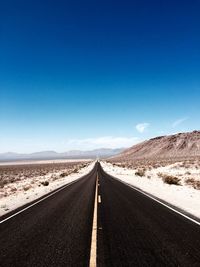 Empty road along countryside landscape