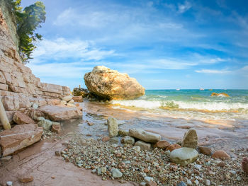 Rocks on beach against sky