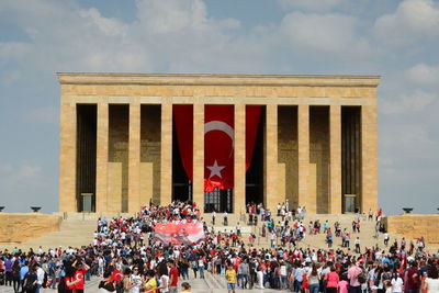 Group of people in front of historical building against sky