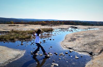 Full length of girl in lake against clear sky