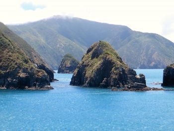 Scenic view of sea and mountains against sky