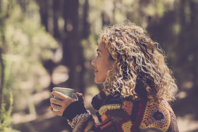 Side view of woman holding coffee cup