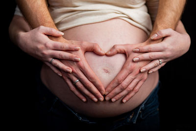 Midsection of woman touching finger