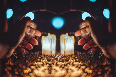 Close-up of hands holding candles